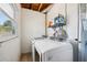 Efficient laundry room with modern washing machine and dryer, a window and storage shelving for cleaning products at 1450 Seabreeze St, Clearwater, FL 33756