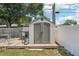 This backyard features a large gray shed with doors and a small deck and play house nearby at 1450 Seabreeze St, Clearwater, FL 33756