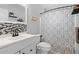 Bright bathroom featuring a modern vanity with sleek faucet and a decorative shower curtain at 1489 77Th N Ave, St Petersburg, FL 33702