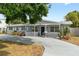 Charming single-story home with a inviting front porch, well-manicured lawn, and a spacious driveway at 1489 77Th N Ave, St Petersburg, FL 33702