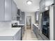 Modern kitchen featuring gray cabinets, stainless steel appliances, and white countertops, perfect for culinary enthusiasts at 1489 77Th N Ave, St Petersburg, FL 33702