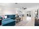Inviting living room featuring a comfortable blue sectional sofa, a modern ceiling fan, and stylish decor at 1489 77Th N Ave, St Petersburg, FL 33702