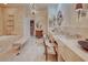 Spacious primary bathroom with marble finishes, chandelier, dual sink vanity, tub, and adjacent walk-in closet at 1515 Park N St, St Petersburg, FL 33710