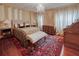 Spacious main bedroom featuring a plush bed, decorative rug, chandelier, and ample natural light from elegant draperies at 1515 Park N St, St Petersburg, FL 33710