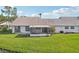Home's backyard featuring an enclosed porch, patio area and a well manicured yard at 1613 Comfy Ct, Sun City Center, FL 33573