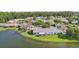 Waterfront home featuring a backyard with a screened in lanai and lush green grass at 1613 Comfy Ct, Sun City Center, FL 33573