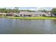 Waterfront home featuring a backyard with a screened lanai and lush green grass at 1613 Comfy Ct, Sun City Center, FL 33573