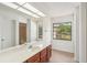 Bright bathroom with a large mirror, modern lighting and outside view at 1613 Comfy Ct, Sun City Center, FL 33573