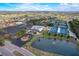 Aerial view of the community center with tennis courts and a pond in the background at 1613 Comfy Ct, Sun City Center, FL 33573
