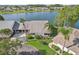 Waterfront home featuring mature landscaping, lush lawn, and views of the lake at 1613 Comfy Ct, Sun City Center, FL 33573