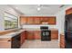 Functional kitchen featuring wood cabinets, black appliances and water view at 1613 Comfy Ct, Sun City Center, FL 33573