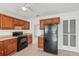 Functional kitchen with wood cabinets, black appliances and tile flooring at 1613 Comfy Ct, Sun City Center, FL 33573