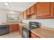 Traditional kitchen featuring wood cabinets, black appliances and a window with water view at 1613 Comfy Ct, Sun City Center, FL 33573