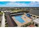 Aerial view of a large community pool, jacuzzi, and lounge area with umbrellas for shade on a sunny day at 1613 Comfy Ct, Sun City Center, FL 33573