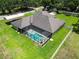 Aerial view of a screened pool surrounded by lush green lawn and a white fence at 16220 Lake Armistead Way, Odessa, FL 33556