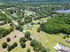 Expansive aerial view showcases homes with pools amidst a verdant landscape and nearby lake at 16220 Lake Armistead Way, Odessa, FL 33556