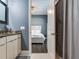 Bathroom with vanity, view to bedroom with white bedding and stylish ceiling fan at 16220 Lake Armistead Way, Odessa, FL 33556