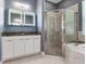 Bathroom featuring a glass-enclosed shower, a double vanity, and modern lighting at 16220 Lake Armistead Way, Odessa, FL 33556