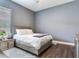 Bedroom with wood floors, a bed, and a bedside table at 16220 Lake Armistead Way, Odessa, FL 33556