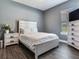 Bedroom with white furniture, gray walls, wood floors and natural light from window at 16220 Lake Armistead Way, Odessa, FL 33556