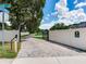 Private driveway entrance with brick pavers and gated access, surrounded by lush landscaping and fencing at 16220 Lake Armistead Way, Odessa, FL 33556
