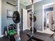 Well-equipped exercise room featuring free weights, weight rack and bench on black floor at 16220 Lake Armistead Way, Odessa, FL 33556