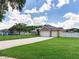 Well-maintained home with a three-car garage, fenced yard, and brick driveway, set in a serene neighborhood at 16220 Lake Armistead Way, Odessa, FL 33556