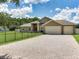 Inviting home featuring a three-car garage, fenced yard, and a spacious driveway, perfect for Gathering living at 16220 Lake Armistead Way, Odessa, FL 33556