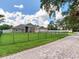 Sprawling one-story home featuring a manicured lawn and a secure iron fence at 16220 Lake Armistead Way, Odessa, FL 33556