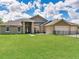 A spacious lawn fronts this inviting single-story home with a convenient three-car garage at 16220 Lake Armistead Way, Odessa, FL 33556