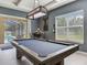 Game room including a pool table, desk, and access to the outdoor pool at 16220 Lake Armistead Way, Odessa, FL 33556
