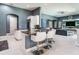 Elegant kitchen island featuring white bar stools and seamless transition to the living room at 16220 Lake Armistead Way, Odessa, FL 33556