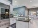 Spacious kitchen with white cabinets, granite countertops, stainless appliances, and kitchen island overlooking the pool at 16220 Lake Armistead Way, Odessa, FL 33556