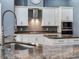 Kitchen featuring stainless steel appliances, granite countertops, and white cabinetry at 16220 Lake Armistead Way, Odessa, FL 33556