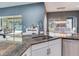 Open kitchen featuring granite countertops, stainless steel appliances, white cabinets, and an eat-in bar at 16220 Lake Armistead Way, Odessa, FL 33556