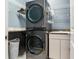 Laundry room featuring gray washer and dryer, marble countertop, and ample storage at 16220 Lake Armistead Way, Odessa, FL 33556