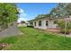 Lush green backyard featuring a storage shed, a manicured lawn, and a quaint picket fence at 1666 Souvenir Dr, Clearwater, FL 33755