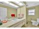This bathroom features a large mirror, a vanity, a toilet, and a window at 1666 Souvenir Dr, Clearwater, FL 33755