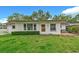 Charming single-story home featuring a well-maintained lawn, tidy shrubbery, and a welcoming front porch at 1666 Souvenir Dr, Clearwater, FL 33755