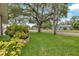 Lush front yard with colorful foliage and mature trees surrounding a charming residential home at 1666 Souvenir Dr, Clearwater, FL 33755