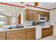 Kitchen featuring wood cabinets, updated appliances, and access to an eat-in area at 1666 Souvenir Dr, Clearwater, FL 33755