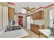 The kitchen features a double sink, wood cabinets, and a window looking out to the yard at 1666 Souvenir Dr, Clearwater, FL 33755