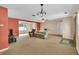 Spacious living room with carpet flooring, ceiling fan, and natural light streaming through the windows at 1666 Souvenir Dr, Clearwater, FL 33755