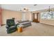 Bright living room with a large window, comfortable seating, and neutral carpet throughout at 1666 Souvenir Dr, Clearwater, FL 33755
