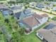 Aerial view of a home with a screened-in pool, solar panels, lush landscaping, and a well-manicured lawn at 1696 Hidden Springs Dr, Trinity, FL 34655