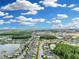 High angle aerial view of a neighborhood, showcasing streets lined with homes and tranquil ponds surrounded by green landscapes at 1696 Hidden Springs Dr, Trinity, FL 34655