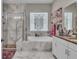 Elegant bathroom with a soaking tub, a glass-enclosed shower, and stylish marble accents at 1696 Hidden Springs Dr, Trinity, FL 34655