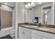 Bathroom features a double sink vanity, granite countertops and a tub with tile surround at 1696 Hidden Springs Dr, Trinity, FL 34655