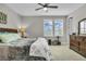 Bedroom with a ceiling fan, a comfortable queen-size bed, and bright natural light from the double windows at 1696 Hidden Springs Dr, Trinity, FL 34655