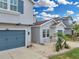 Charming two-story home with a blue garage door, well-manicured lawn, and lush landscaping on a sunny day at 1696 Hidden Springs Dr, Trinity, FL 34655
